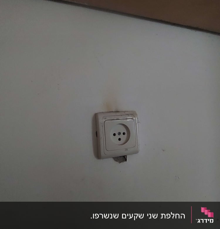 שקע חשמלי בקיר עם סימני שחיקה